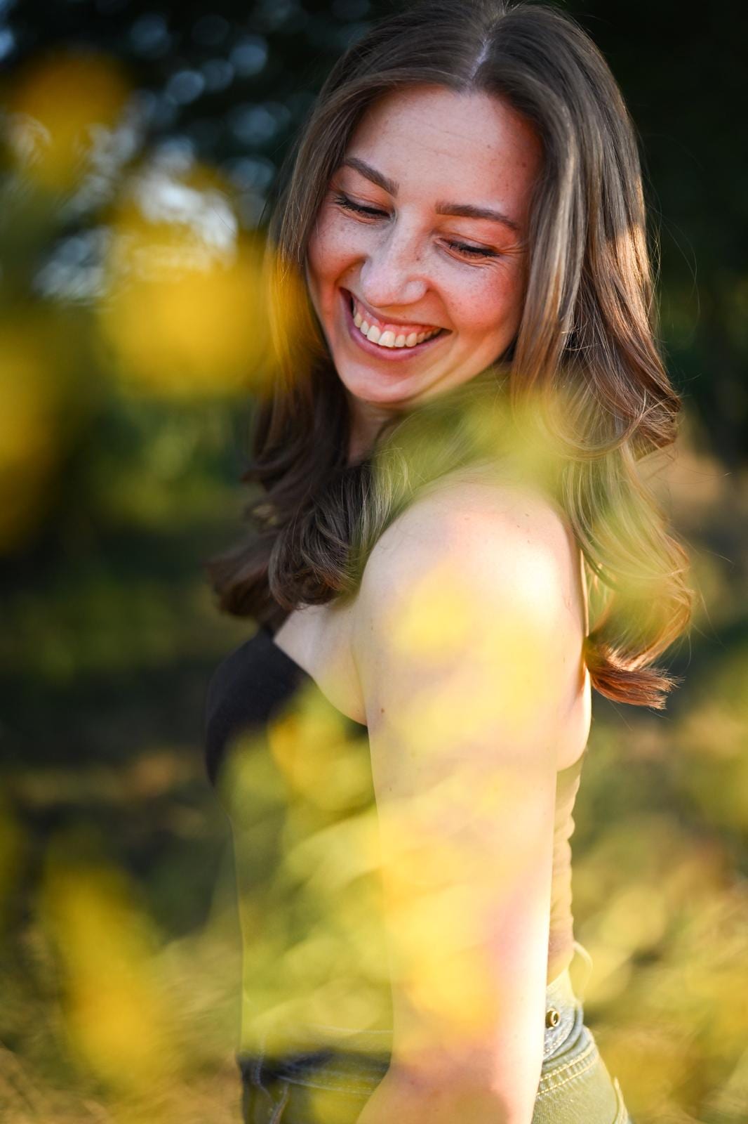 Junge Frau lacht im Sonnenlicht