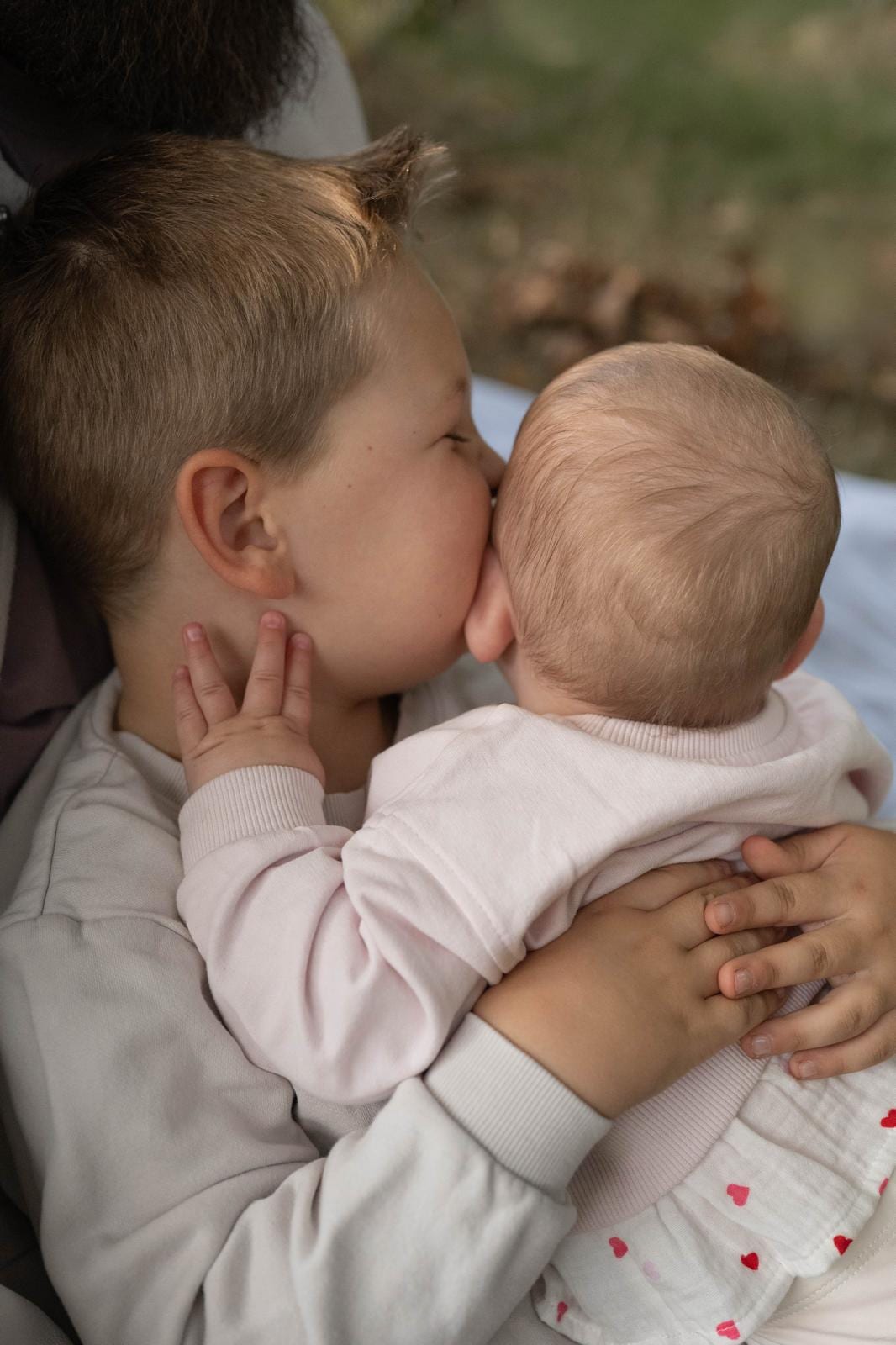 Großer Bruder küsst seine kleine Schwester