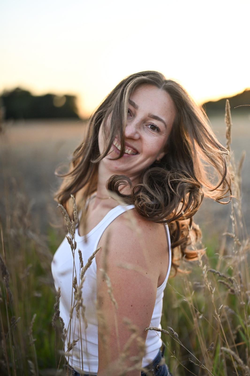 Junge Frau mit wehenden Haaren im Feld