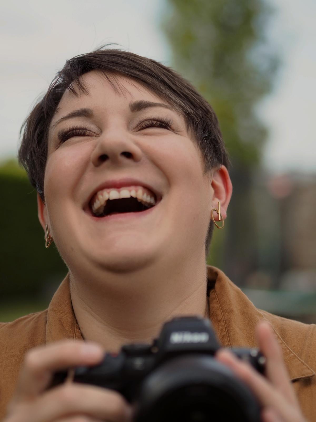 Laura Schmidt lacht mit ihrer Kamera in der Hand